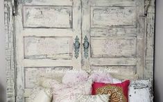 an old white door is decorated with pillows and throw pillow covers for a rustic look