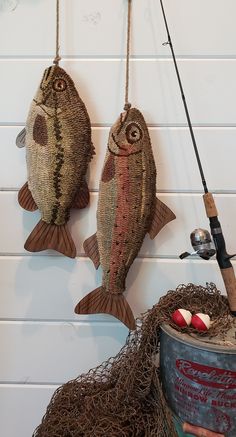 two fish hanging from hooks on the wall