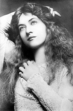 an old black and white photo of a woman with her hair blowing in the wind