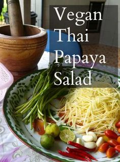 there is a plate with pasta and veggies on it, next to a potted plant