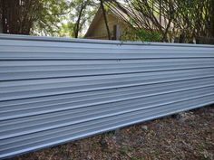 a metal fence in front of some trees