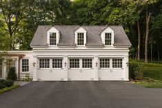 a white two story house with three windows on the top floor and one above the garage