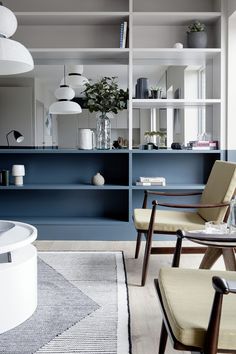 a living room filled with lots of furniture and shelves covered in blue bookshelves