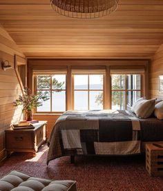 a bedroom with wood paneling and large windows