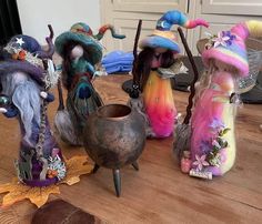 four little fairy figurines sitting on top of a wooden table