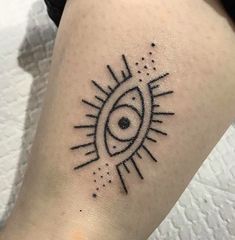 a tattoo on the leg of a woman with an eye and sun in the background