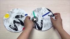 two paper plates with hands on them, one is holding a paintbrush and the other has