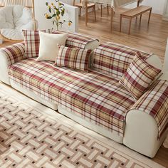 a plaid couch with pillows on it in a living room