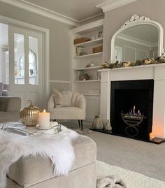 a living room filled with furniture and a fire place in front of a mirror on the wall