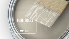 a paint can with a brush in it and the words dune grass painted on it