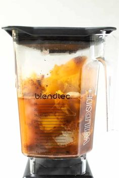 blender filled with liquid on top of a black countertop against a white background