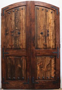 two wooden doors with metal hardware on them