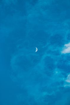 the moon is in the blue sky with clouds