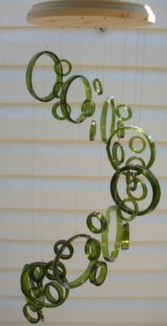 a wind chime hanging from the side of a window with green swirls on it