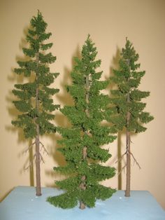 three small trees sitting on top of a blue table