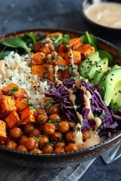 a bowl filled with rice, beans, avocado and other food on top of a table