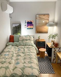 a bed sitting in a bedroom next to a wooden table and lamp on top of a hard wood floor