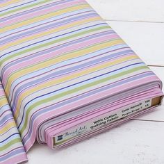 a colorful striped cloth laying on top of a white wooden floor