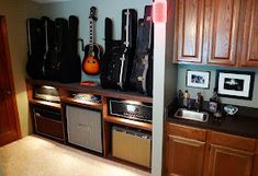 guitars and amps are lined up against the wall in this kitchen with wood cabinets