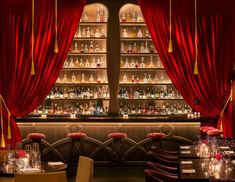 the interior of a restaurant with red curtains