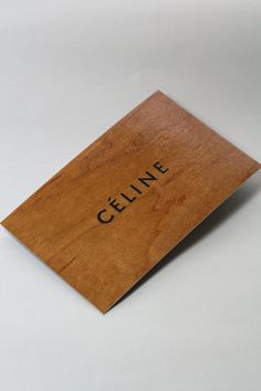 a piece of wood with the word cellne written on it in black ink, sitting on a white surface