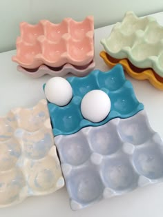 three egg trays sitting on top of a table next to an egg in the middle