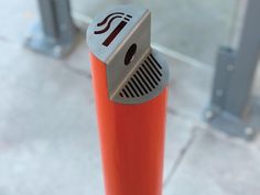 an orange pole with a metal object on it's top and the letter i in red