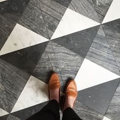 a person standing on top of a black and white tiled floor