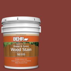 a bucket of wood stain sitting on top of a pink background with the words behr