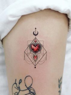 a woman's thigh with tattoos on it and a heart in the shape of a star