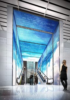 people are walking up and down an escalator in a building with blue walls