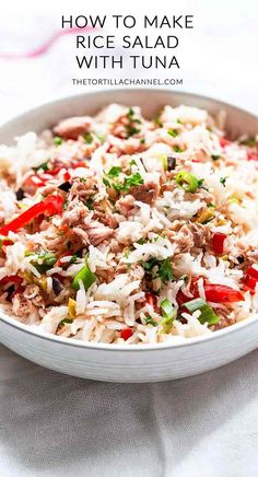 a white bowl filled with rice and vegetables on top of a table next to a fork