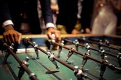 two men are working on an old foosball table with lots of screws