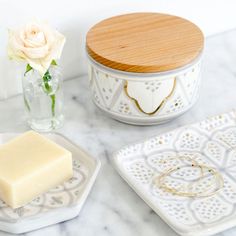 two white dishes and a wooden lid on a marble table