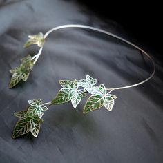 From the Czech Republic, artist Marie Hartingerova employs her proprietary technique to transform bottles into exquisite flowers and leaves. These botanical creations are then delicately fused onto stainless steel necklaces, rings, earrings, and bracelets, resulting in uniquely sophisticated statement pieces that blend nature's elegance with refined design. Imagine the delicate ivy leaves gracefully wrapping around your collar bone, creating a mesmerizing aura. Ivy leaves are often associated with resilience, growth, and eternity. Wearing this necklace can serve as a reminder of your strength and the continuous journey of personal growth. The necklace is not just an accessory; it's a statement piece that speaks to your love for nature and your ethereal spirit. Handmade item Necklace length Ivy Necklace, Ivy Ring, Grit And Grace, Ivy Leaves, Stained Glass Jewelry, Collar Bone, Ivy Leaf, The Czech Republic, Jewelry Tree