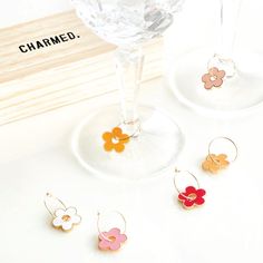 Let your drinks bloom with Daisy Wine Glass Charms! These drink tags feature daisies in six vibrant colors, including shades of pink, orange, and white, each delicately suspended on a gold loop. Presented in a pine wood box, they're perfect for effortless gifting and convenient storage. Place these adorable drink charms around the stems of your wine or champagne glasses to keep track of your drinks. Whether hosting a spring garden party, a daisy baby shower, a tropical birthday bash, a bachelore Coastal Style Kitchen, Daisy Baby Shower, Wine Glass Charm, Spring Garden Party, Drink Tags, Appreciation Thank You, Tropical Birthday, Glass Charms, Wine Glass Charms