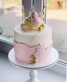 a pink and white cake with gold decorations