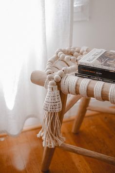 a wooden bench sitting on top of a hard wood floor next to a white curtain