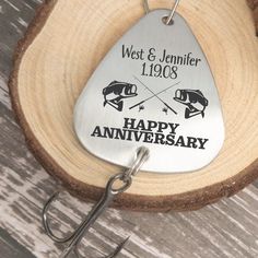 a metal keychain with a happy anniversary tag attached to it on a wooden surface