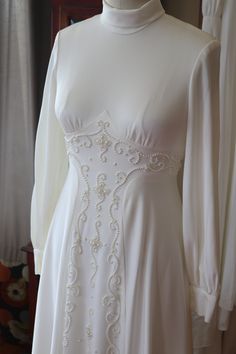 a white wedding dress on display in a room