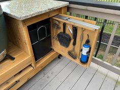 an outdoor kitchen with pots, pans and utensils in the cabinet door