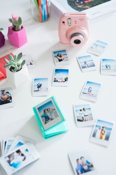 a table topped with polaroid pictures and a camera