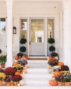 an instagram page with pumpkins and flowers on the front steps in front of a house