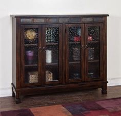 a wooden cabinet with glass doors and shelves on the front, sitting in a living room