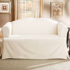 a living room with a couch covered in a white cover