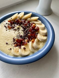 a blue bowl filled with bananas and other food on top of a white countertop