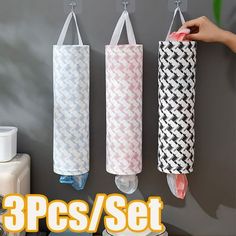 three rolls of toilet paper hanging from hooks on a wall with the words 3 pcs / set