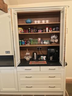 an open cabinet with coffee maker and other items in it