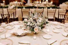 a table set with plates, silverware and centerpieces for a wedding reception