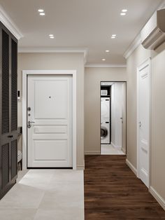 an empty hallway leading to a washer and dryer in a home with wood flooring